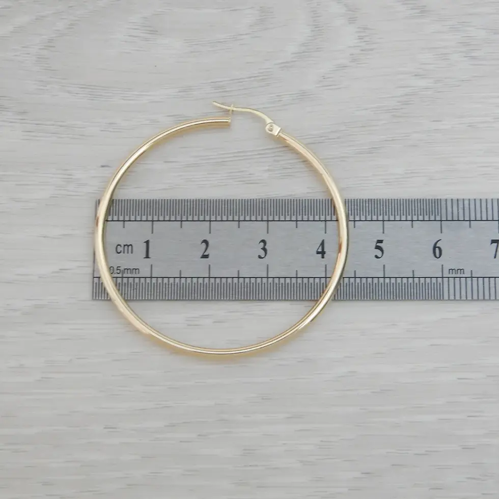 Thumbnail: Single 44mm yellow gold tubular hoop earring beside ruler for size reference