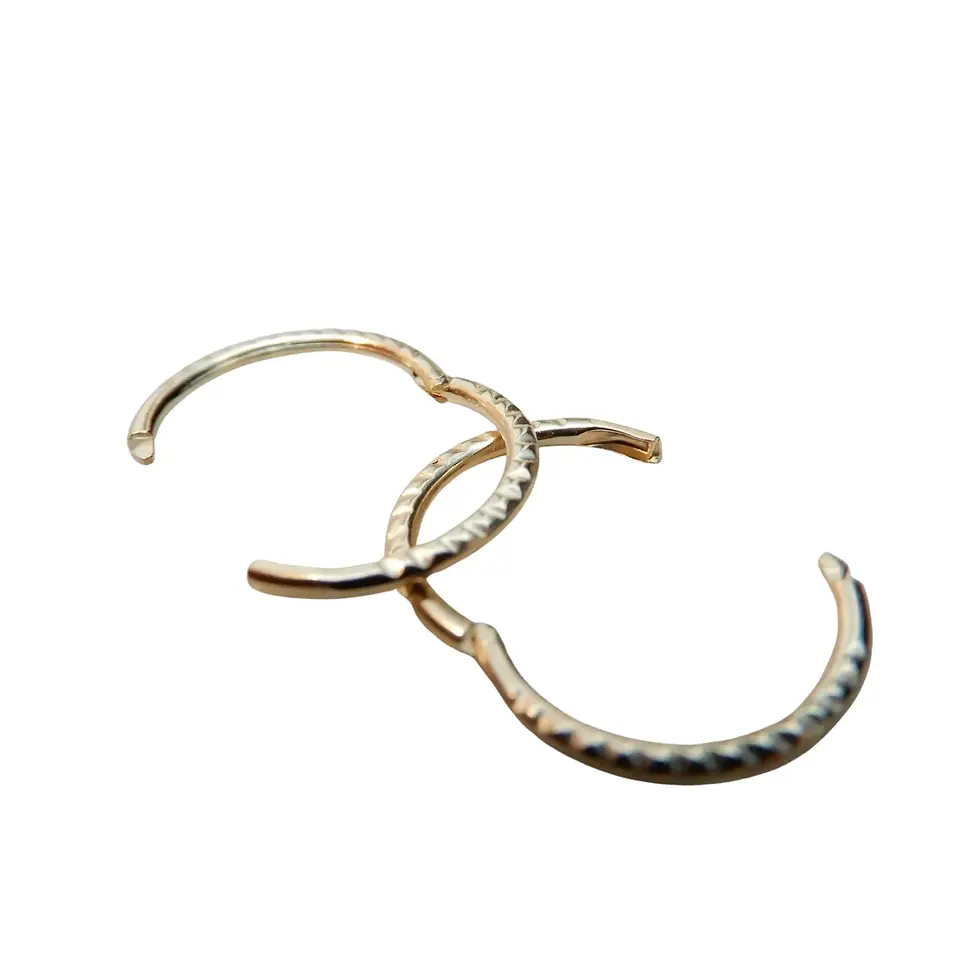 Thumbnail: Two 10mm yellow gold twist sleeper earrings displayed on top of each other on black background