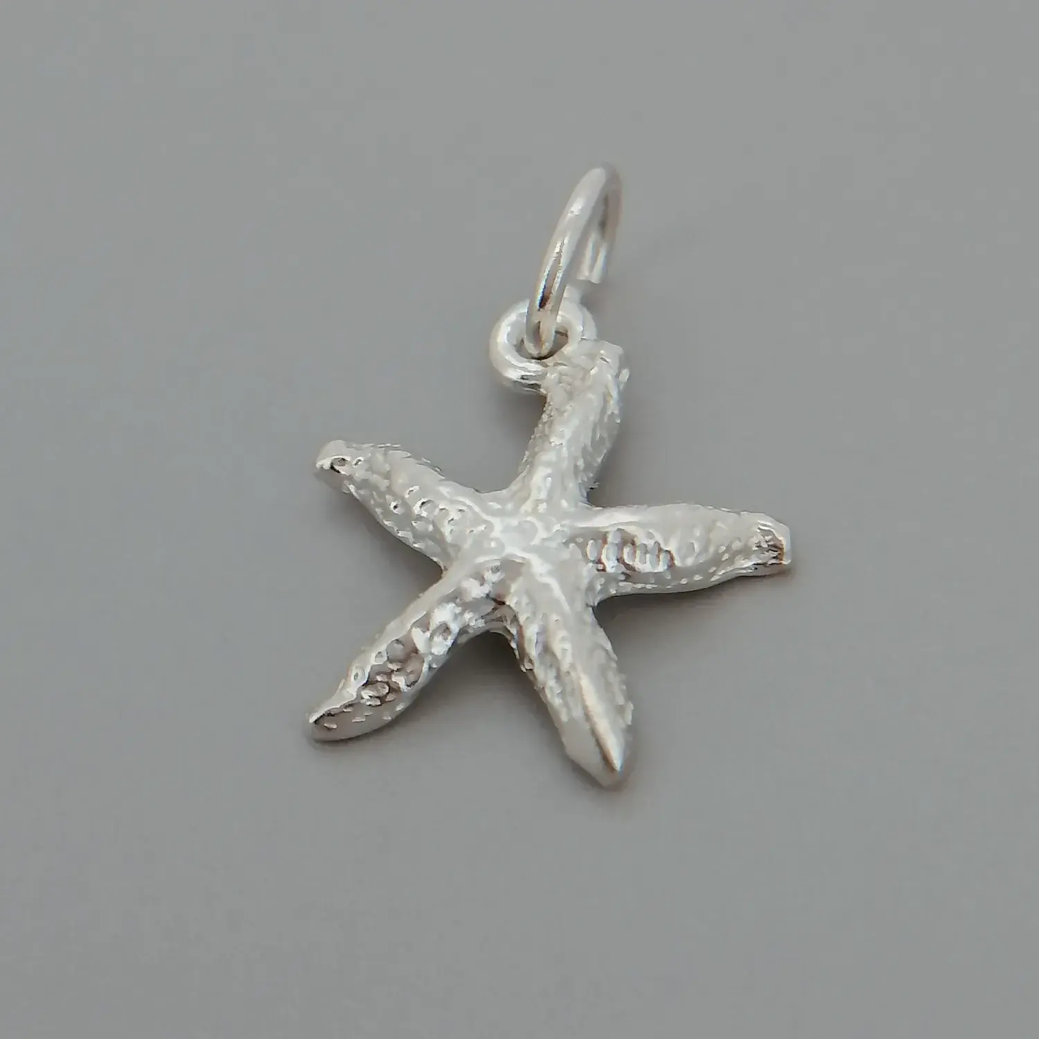 Sterling silver starfish charm with polished ocean-inspired design