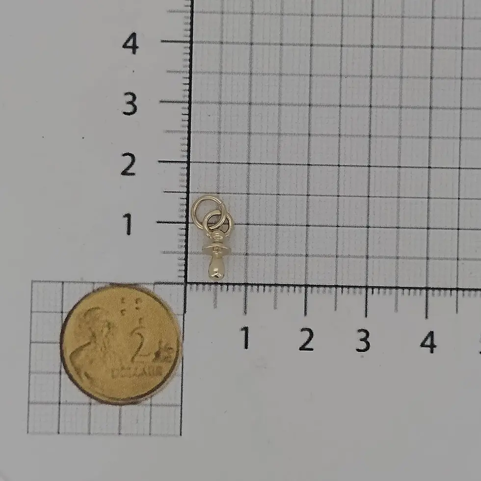 Thumbnail: 9ct yellow gold baby dummy charm shown with ruler and coin for scale