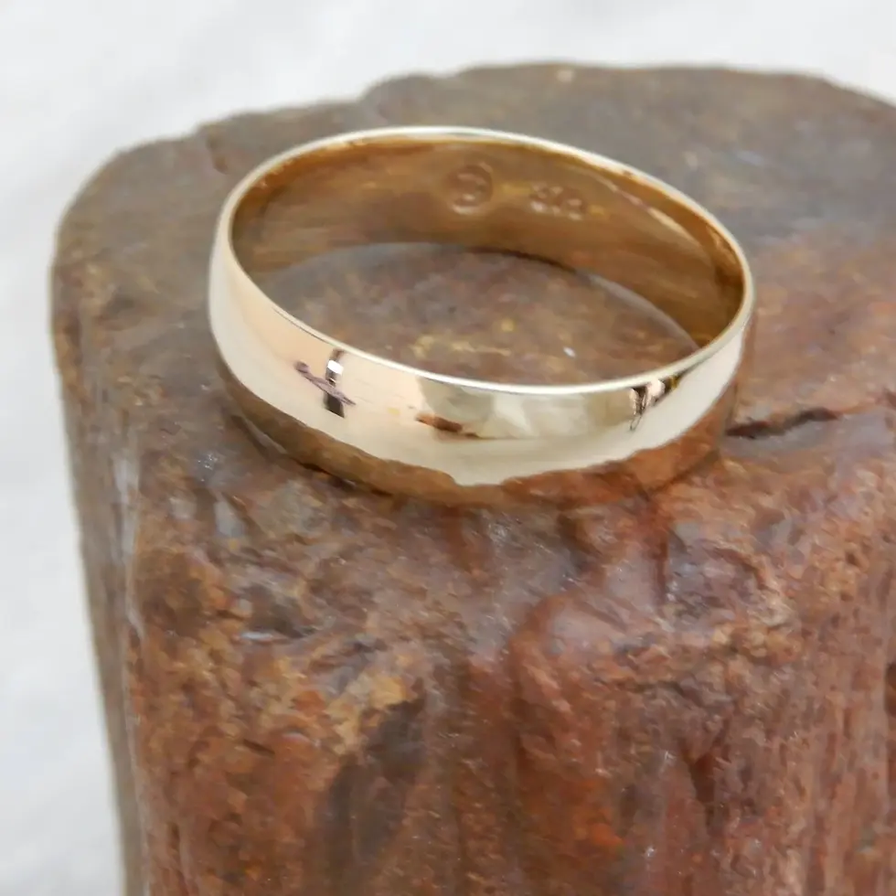 Thumbnail: Classic comfort fit wedding ring in polished 9ct yellow gold shown upright on stone