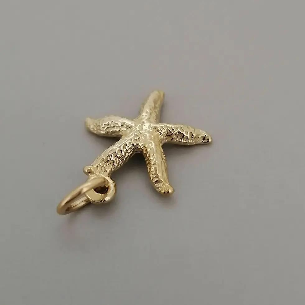 Thumbnail: Gold starfish charm pendant angled slightly downward with textured detail