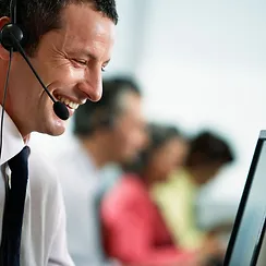 man with headset on in front of a computer