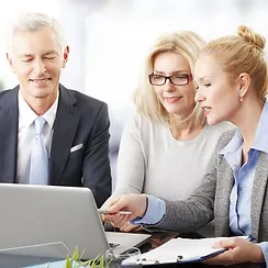 three people looking at a computer