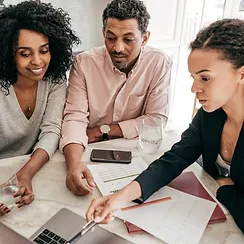 three people looking at laptop