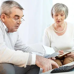 two people with a calculator and checkbook