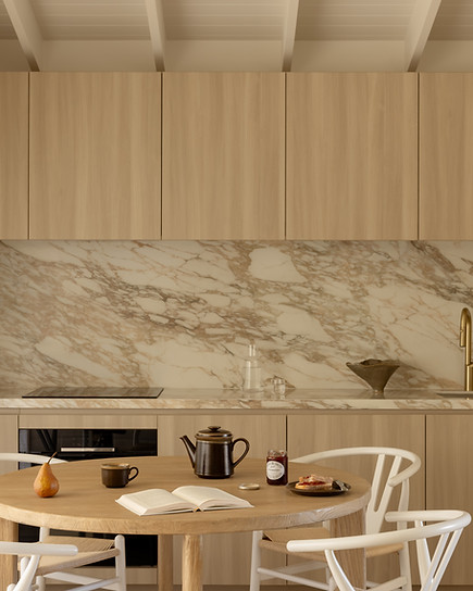 Malia Studio kitchen with stone splashback, dining table and Breville espresso machine