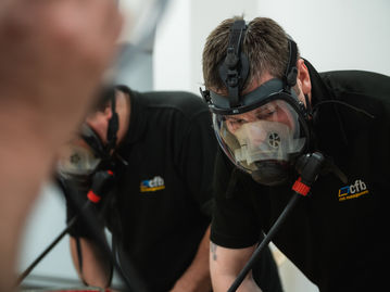 A photo shoot by Jamie Bulman for Infratec Training, a company offering various training courses such as first aid, fire safety, emergency safety training, breath asparagus training, and hazard suit training. The photo features a group of people wearing safety gear and participating in various training activities, such as putting out a fire or performing CPR on a dummy. The participants are learning important skills to keep themselves and others safe in various situations. The photography work helped Infratec Training to promote their courses and increase their sales by 1000%.