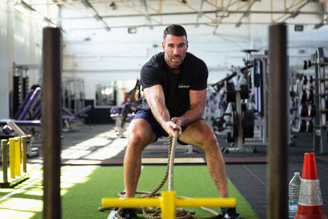 Two male models, showcasing The Empowered Man's online fitness coaching transformation program in a high-quality photo shoot by Jamie Bulman. The models are seen working out and flexing their muscles while wearing The Empowered Man apparel, promoting the 8-week transformation program. The photo shoot helped increase sales by 2000%.
