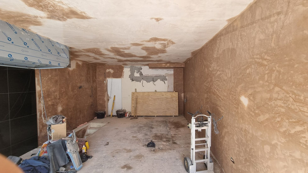 Empty commercial unit during early renovation stage, with unfinished plastered walls and exposed floor — Leo & Co Bespoke.