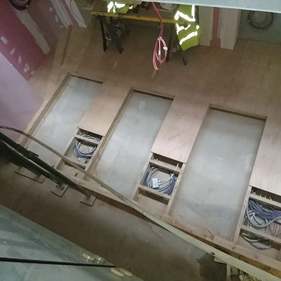 Partially covered raised floor panels with cable management channels prepared underneath — Leo & Co Bespoke.