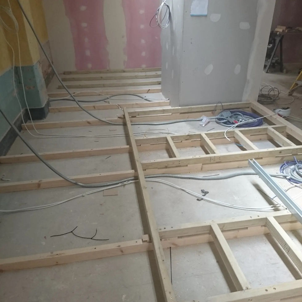 Timber frame structure for raised floor with integrated electrical conduits during early gym fit-out — Leo & Co Bespoke.