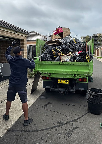 Rubbish Rocket staff member hand loading our truck with mixed household waste for a client in Hills District.