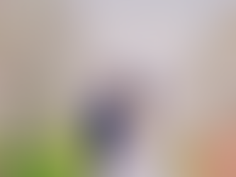 Bruidspaar staat tussen bloeiende lentebomen en kijkt elkaar glimlachend aan, terwijl bloesemblaadjes om hen heen dwarrelen; rechtsonder staat de tekst "Trouwen in de lente"