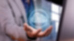 Hand in suit holds glowing "AI" symbol in a cloud. Background features abstract technology with blue tones and soft light.