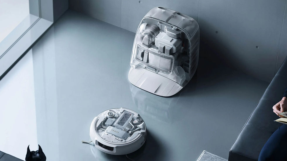 Round robot vacuum and its charging station on a sleek gray floor. A person holding papers is partially visible, with a small black cat nearby.