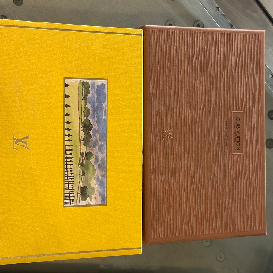 Duas caixas de presente, uma amarela e outra marrom, com logotipos da Louis Vuitton