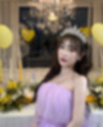 Yoon Er wearing tiara and lavender dress at her birthday setup with candles and balloons.