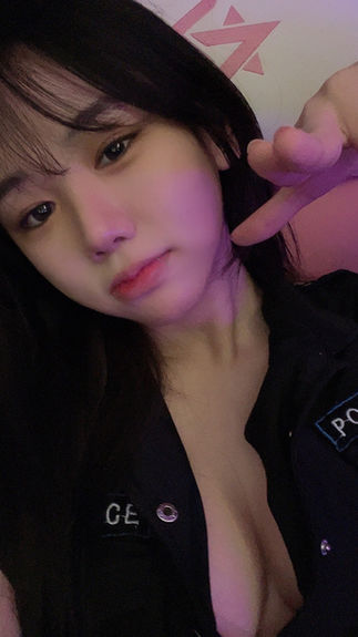 쭈디가 경찰 유니폼을 입고 셀카를 찍으며 가슴골을 드러내고 미소 짓는 모습