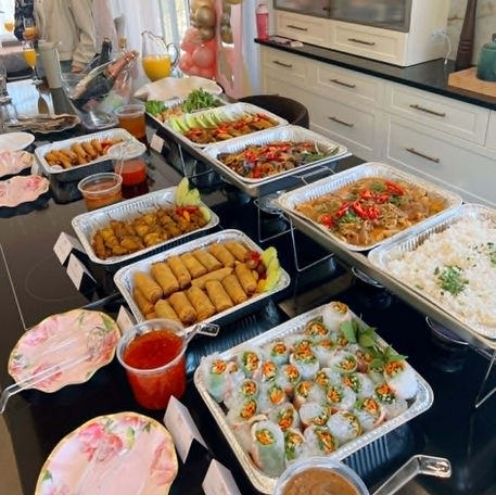 Vue aérienne des plateaux traiteur de Thai Glory Bowl remplis de plats thaïlandais colorés, prêts à être servis.