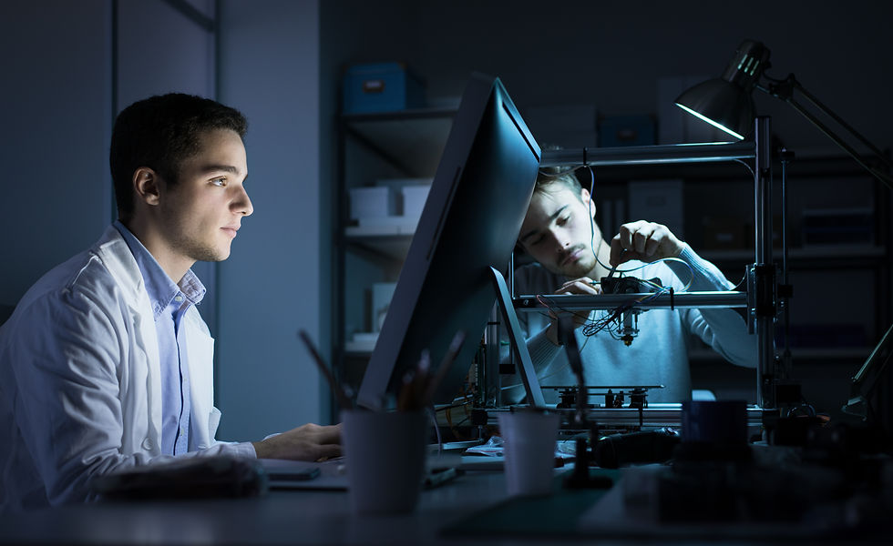 Engineering team working in the lab at night, a student is working with a computer and the