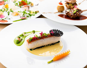 Traditional French cuisine with skyline views, served in an elegant hotel dining room.