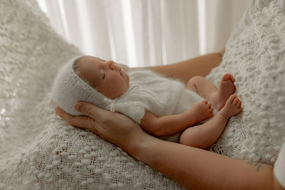 Newborn in a knit bonnet held in parents' hands, Orange City, Iowa newborn photos
