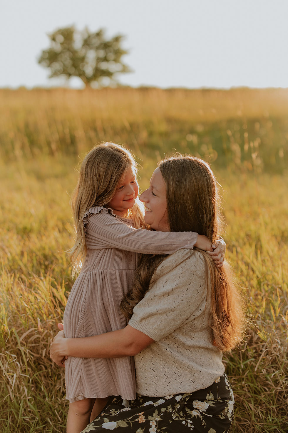 Mom hugging her daughter in a golden field at sunset, Sioux Falls family photographer