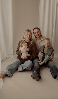 Miranda with her husband and children in a bright studio family portrait