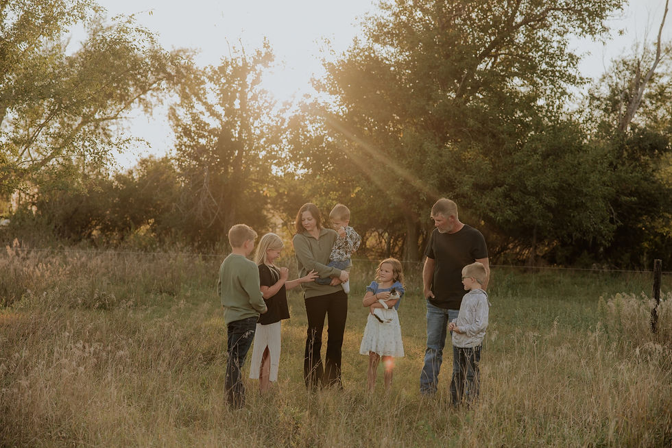 Family playing together in a sunlit grove of trees, Sioux Falls family photography