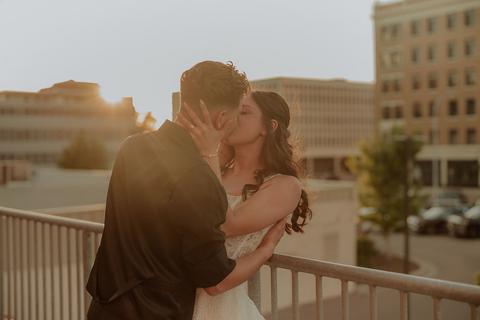 Newlyweds kissing on a downtown balcony at golden hour, Sioux Falls wedding photography