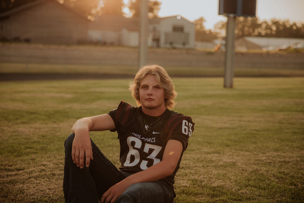 Football senior sitting in the grass at sunset, Sioux City senior pictures