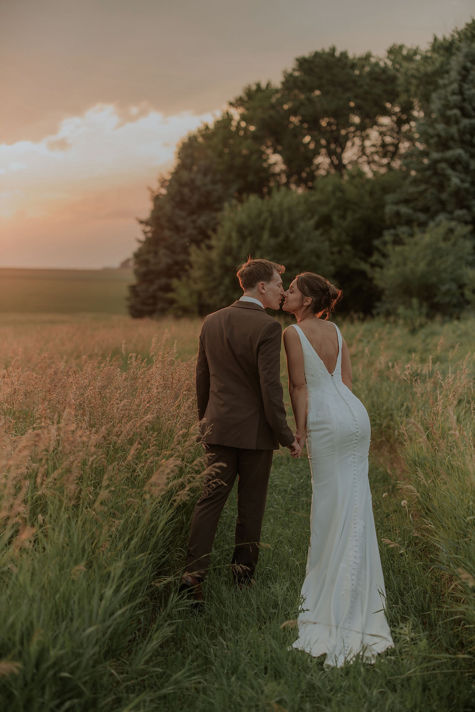 Bride and groom kissing in a tall grass field, Okoboji & Iowa Great Lakes wedding
