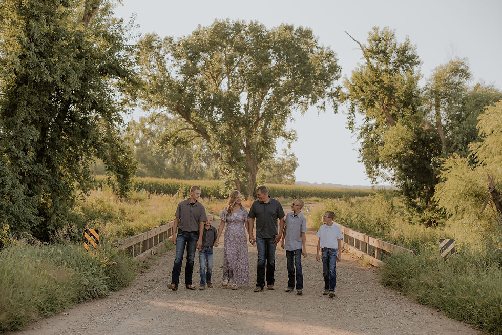 Extended family standing on a tree-lined country road in Northwest Iowa