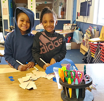 Dos estudiantes en edad escolar haciendo un proyecto en clase