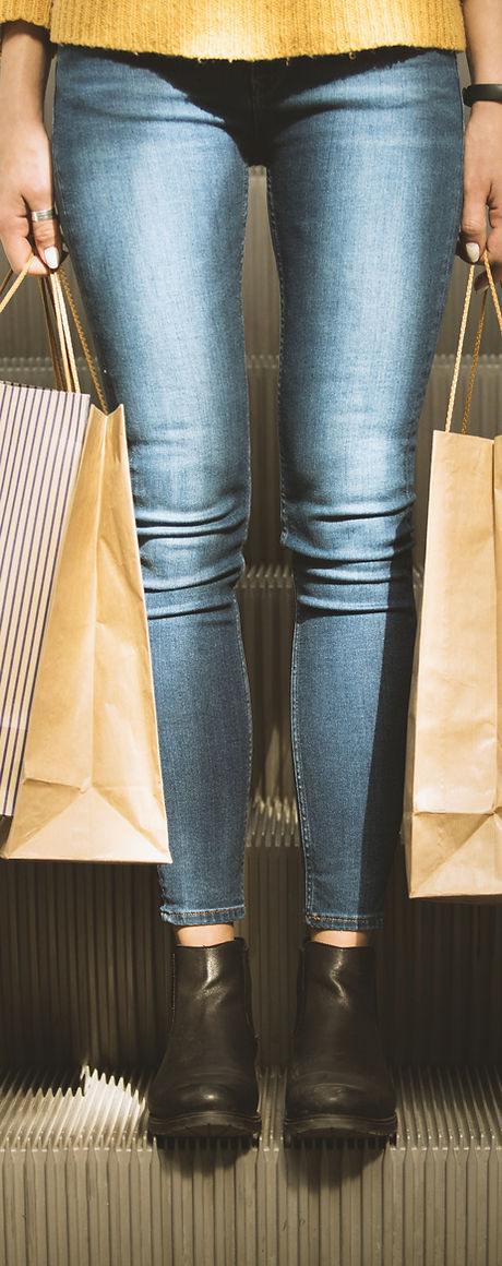 Muchacha que sostiene bolsos de compras