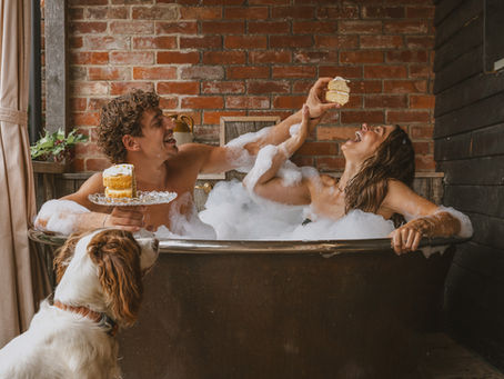 Couple playing in bath at Outbuildings boutique hotel