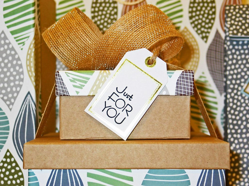 Close-up of a wellness gift basket with a weighted blanket, coloring book, sound machine, journal, and Tim Hortons gift card to celebrate this trauma therapy in London, Ontario practice.