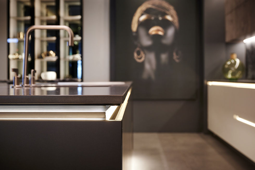 Detailed view of the Senza range's integrated design, featuring an elegant, recessed side table seamlessly attached to the main island, crafted from light wood to provide extended workspace and enhance interconnectivity.