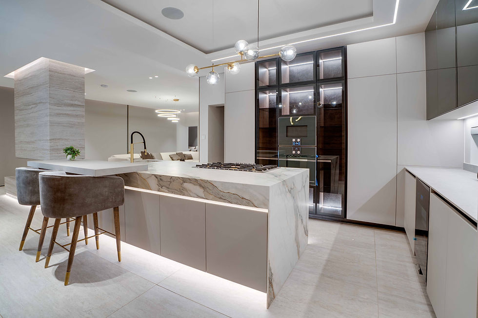 High-end kitchen space highlighting premium materials, including a custom marble island, matte black hardware, and an expansive, light-filled open floor plan.