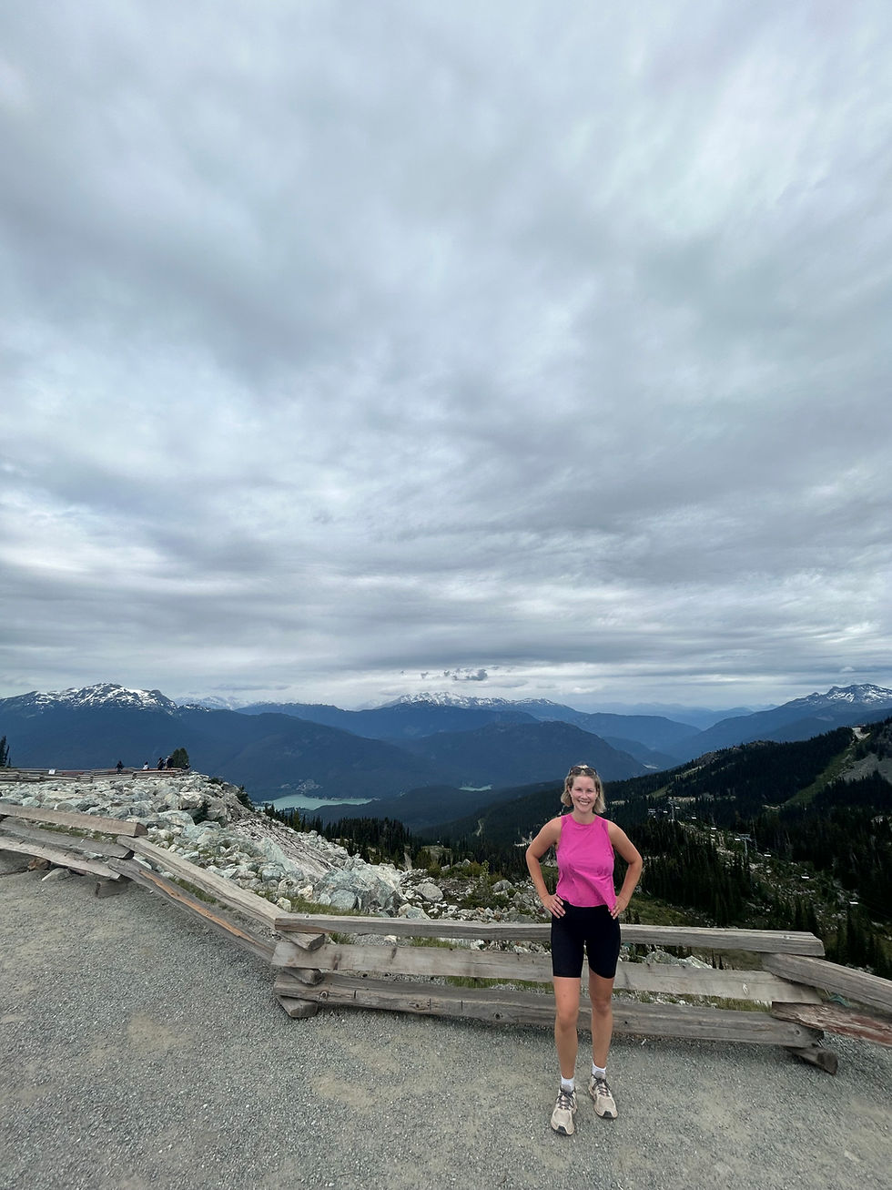 woman in black shorts and pink shirt with whistler mountain in background
