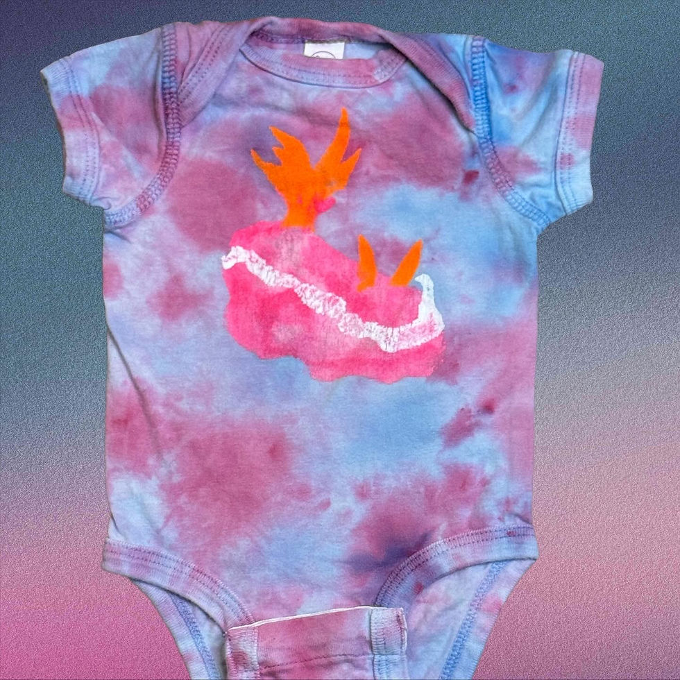 Hand-dyed baby onesie with soft blue and pink tie-dye featuring a bright pink nudibranch sea slug design with orange accents.