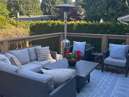 outdoor deck with sectional couch, flowers and trees