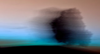 Abstract cloud formation over blue and brown landscape.