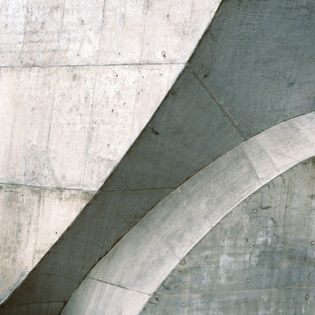 Abstract concrete structures with curved and geometric shapes. Architectural photography, grey hues.
