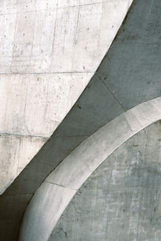 Abstract concrete structures with curved and geometric shapes. Architectural photography, grey hues.