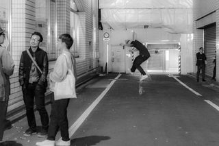 Man jumping in the air, white line, people, architecture, black and white photo.