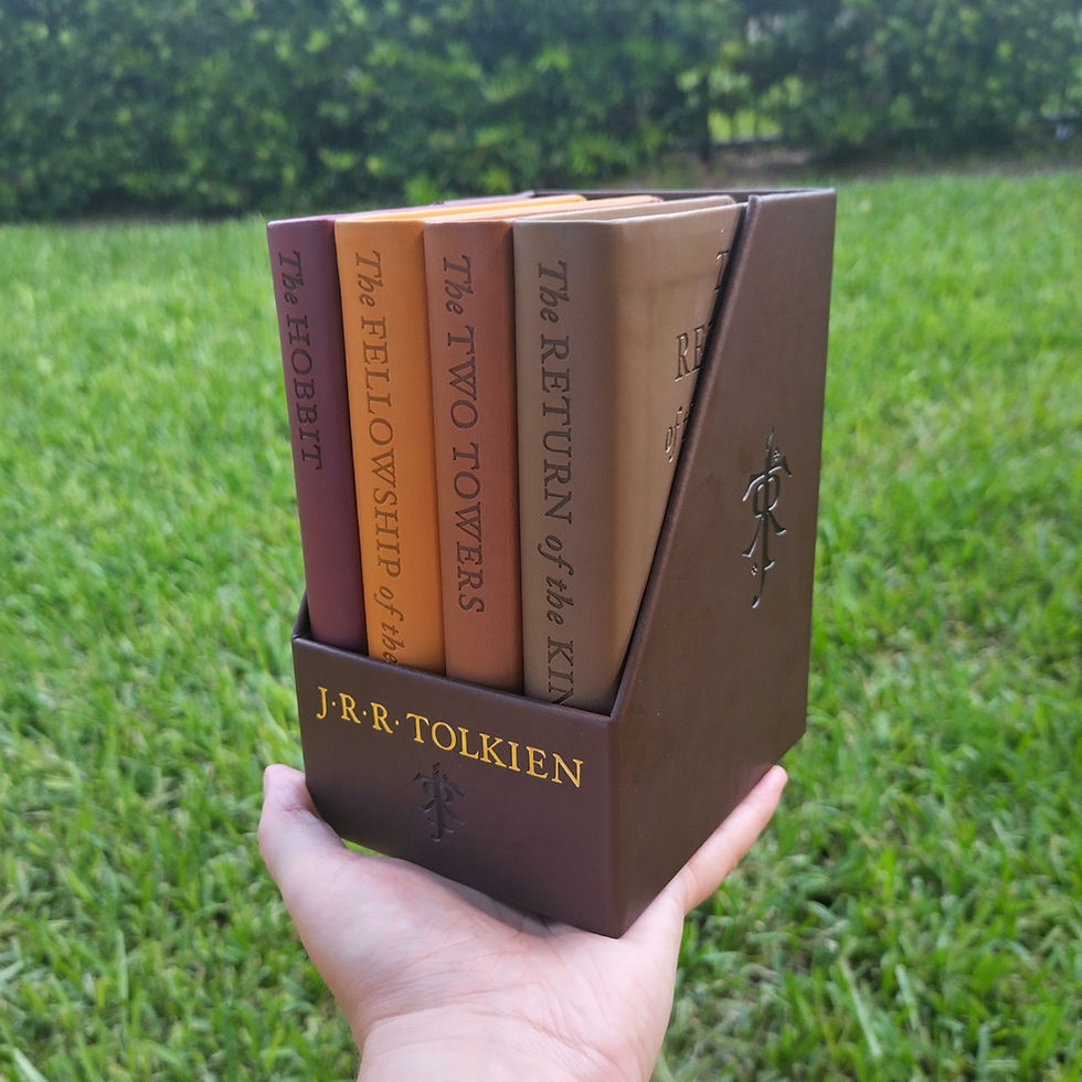 Collection of J. R. R. Tolkien books over a natrual grass background.