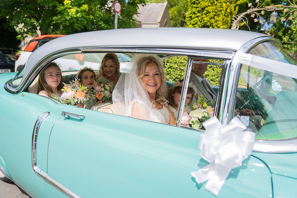 Bridal party arrival in retro wedding car