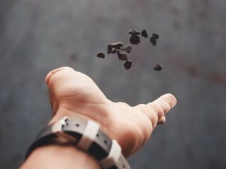 hand outstretched releasing small stones